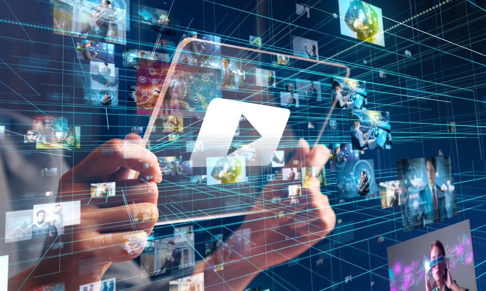 Hands hold a tablet displaying a play button among floating video thumbnails and digital lines.